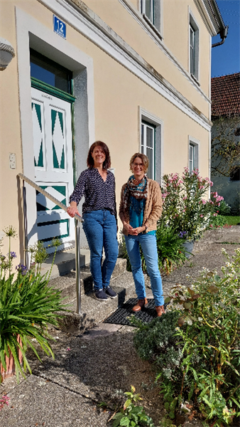zwei Frauen stehen vor einem Haus